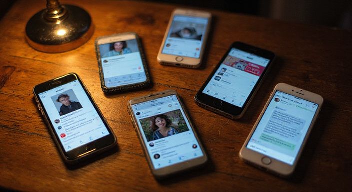 Meerdere smartphones liggen verspreid op een walnoten tafel. Meerdere smartphones liggen verspreid op een walnoten tafel.
